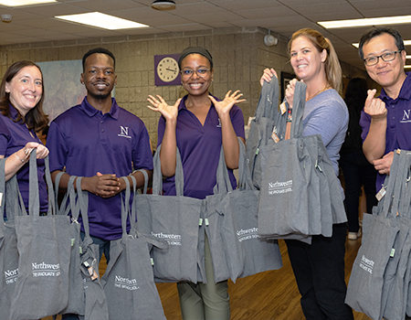 TGS staff members holding tote bags at the Resource Fair