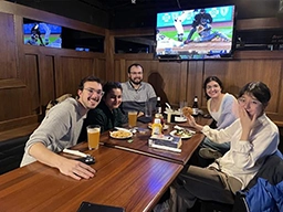 Student with drinks and snacks at pub