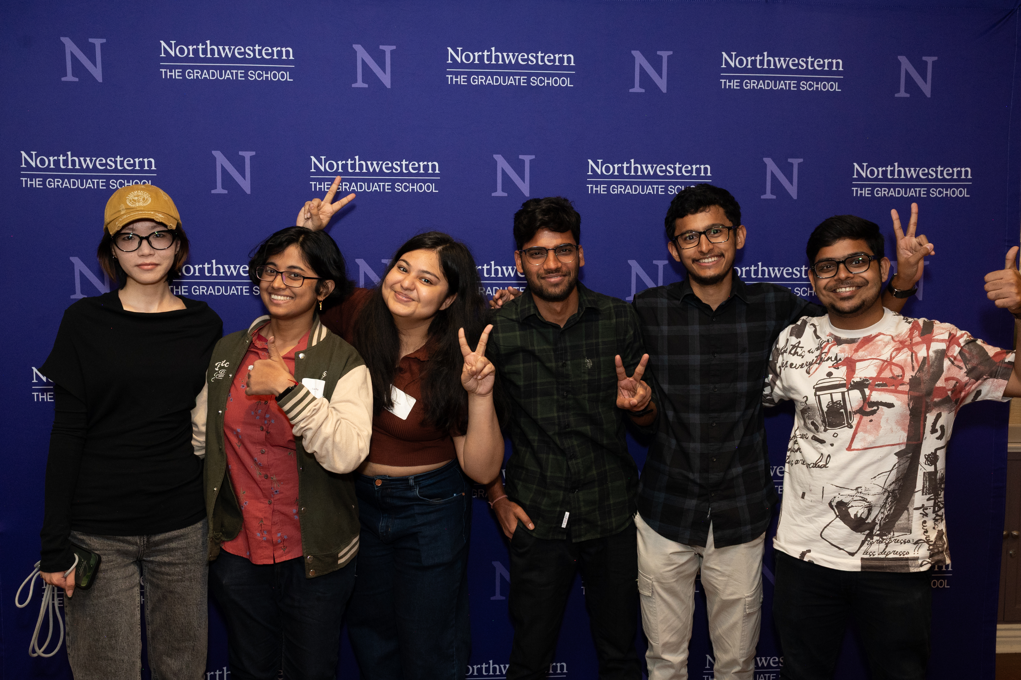 Students posing in front of the Northwestern banner.