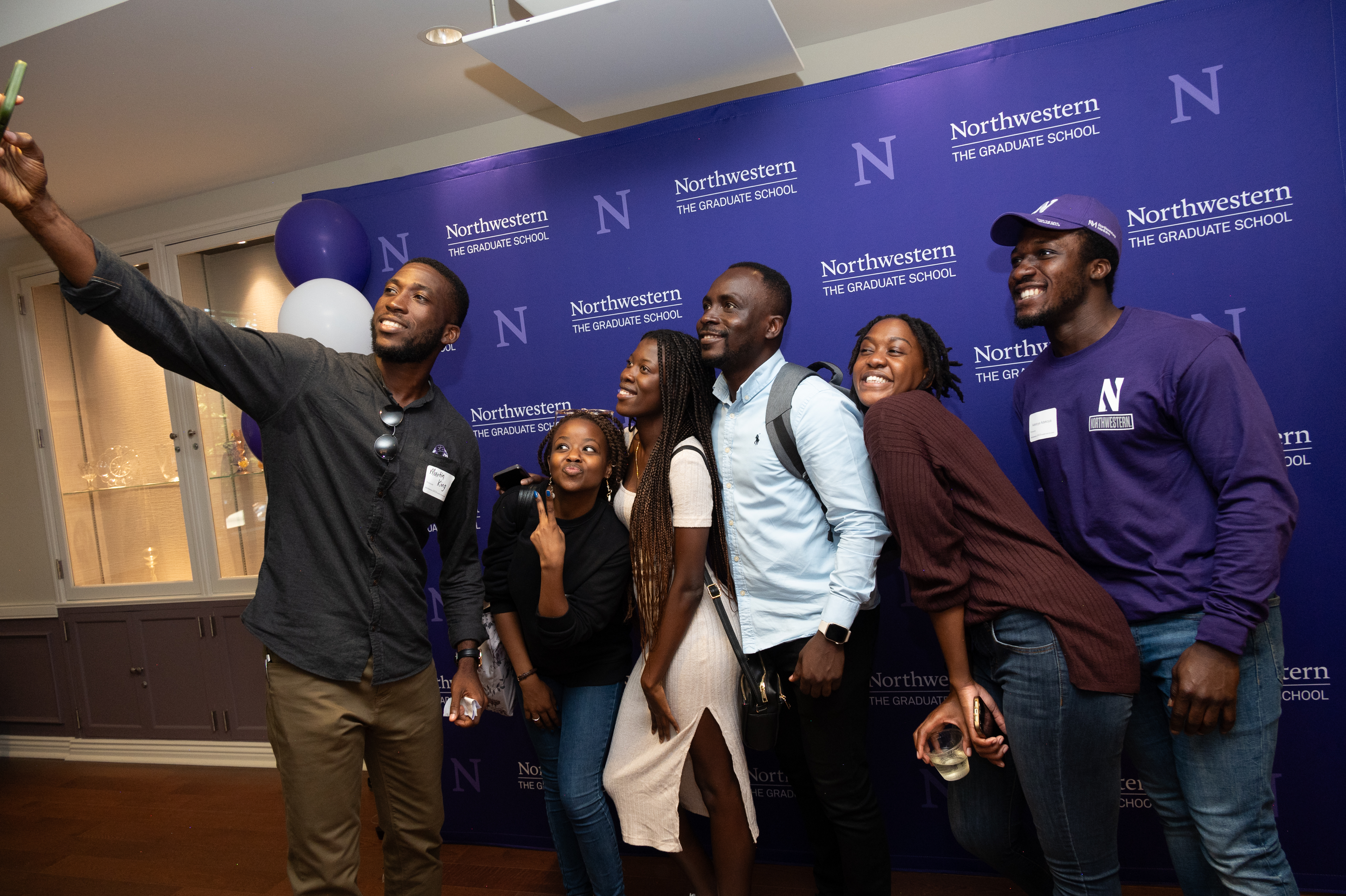 Students taking a selfie in front of a Northwestern background.